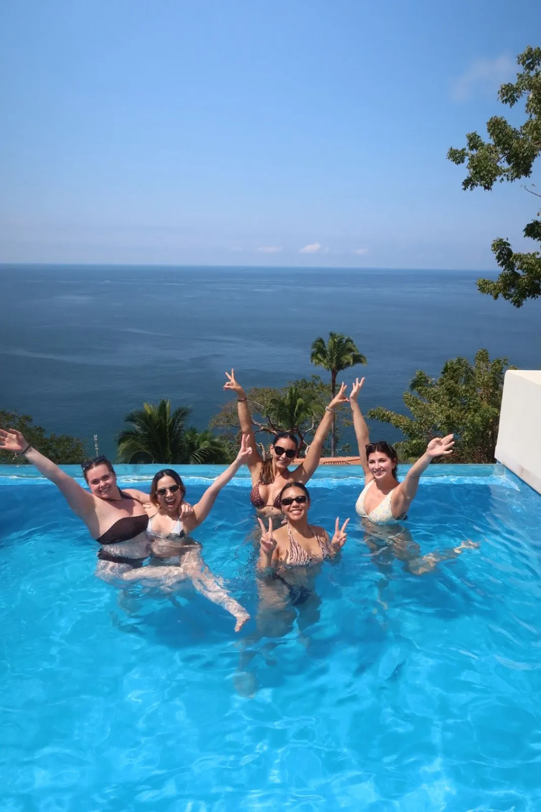 Guests cheering with arms up in the infinity pool